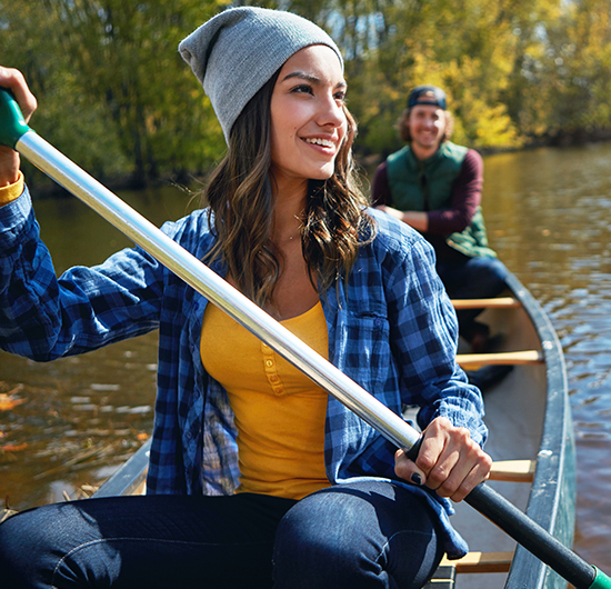 A woman enjoying the outdoors while kayaking, highlighting the freedom and convenience that LASIK and SMILE offer.