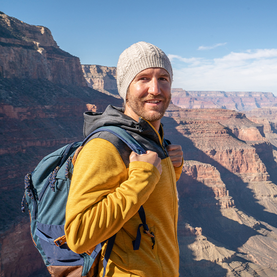 Smiling hiker outdoors enjoying clearer vision after LASIK surgery.