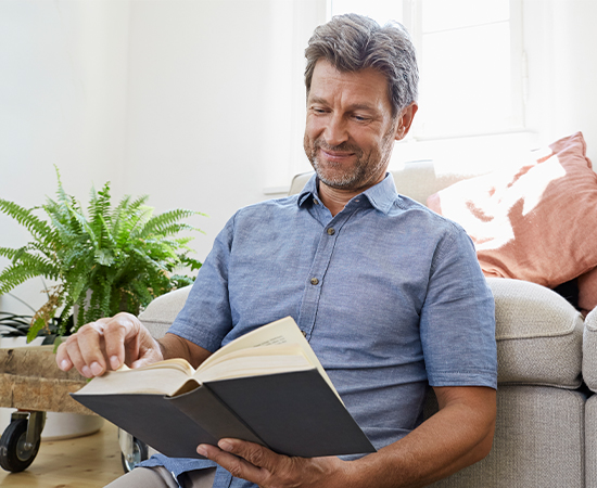 Man reading a book with clearer vision after cataract surgery using premium intraocular lenses.