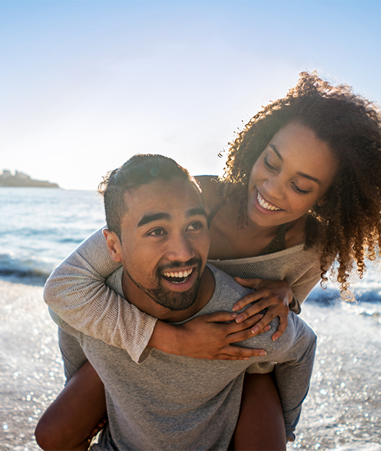 Smiling couple at the beach, after their vision correction procedures at Goel Vision