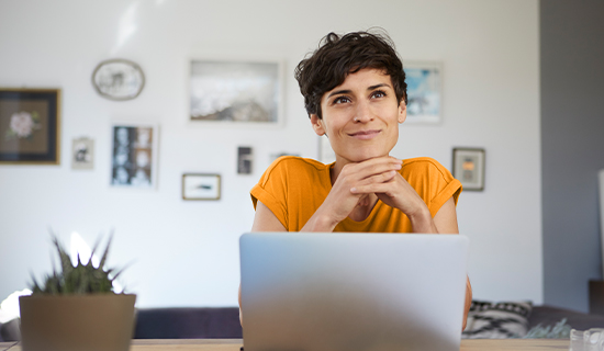 Woman looking thoughtfully at her computer, representing the LASIK savings calculator and financial considerations around LASIK.